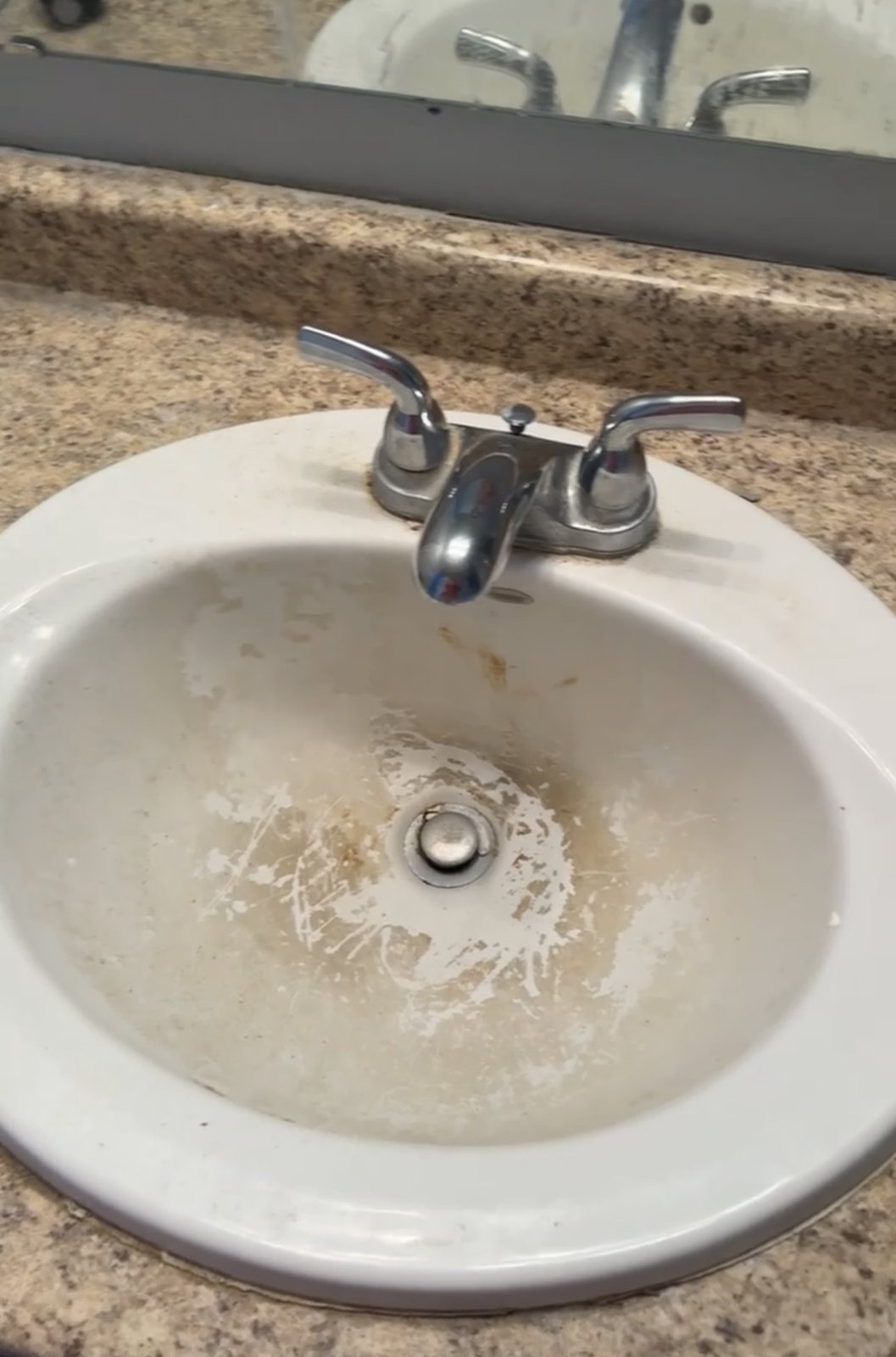 Before cleaning: bathroom sink with visible residue and staining