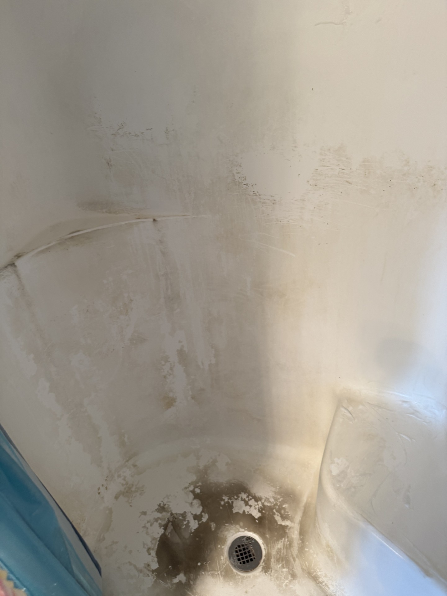 Before cleaning: shower surface with visible buildup and marks