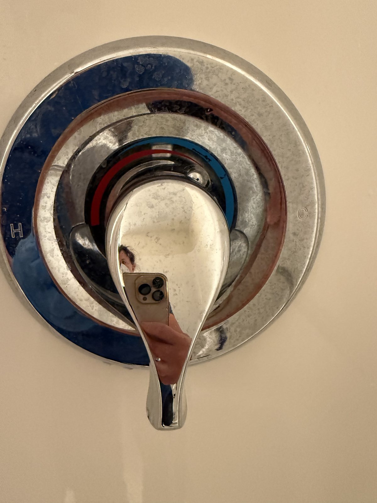 Before cleaning: water spots and buildup around a chrome shower control