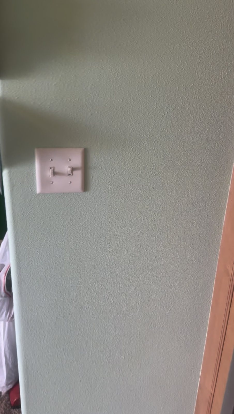 Before cleaning: marks on a green wall around a light switch